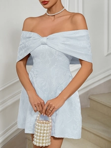 Detail of light blue off-shoulder dress featuring floral jacquard fabric and a large bow