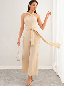 Detail of cross halter neckline and drawstring waist on beige wide leg jumpsuit