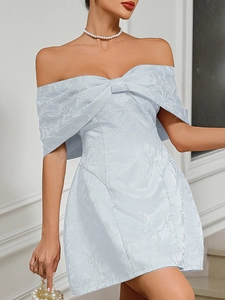 Detailed view of light blue jacquard dress with off-shoulder bow and floral texture