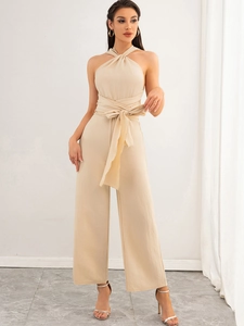 Close-up of beige halter jumpsuit featuring a stylish waist tie and wide leg cut