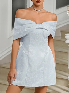 Close-up of elegant light blue jacquard dress featuring a large bow and floral pattern