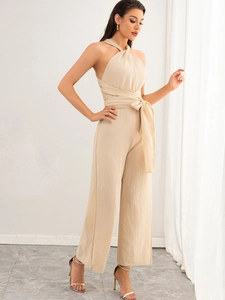 Detailed view of apricot halter jumpsuit with textured fabric and elegant waist tie