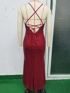 Detail der überkreuzten Rückenschnürung am tiefroten rückenfreien Pailletten-Abendkleid