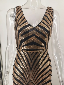 Detail of V-neck sequin dress showing black and gold geometric herringbone patterns