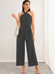 Detail of dark grey halter neck jumpsuit with a criss-cross neckline and belted waist bow