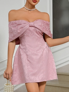 Detail of pink off-shoulder dress featuring jacquard floral fabric and a front bow design