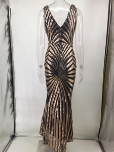 Detail of sequined evening gown featuring gold geometric stripes and a deep V-neckline