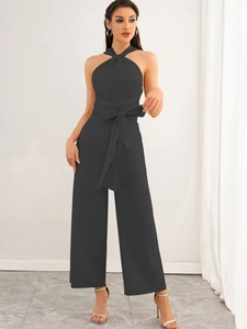 Close-up of halter neck jumpsuit with cross neckline and waist tie-belt detail