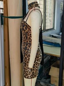 Détail des paillettes léopard scintillantes et du dos en résille de la robe courte
