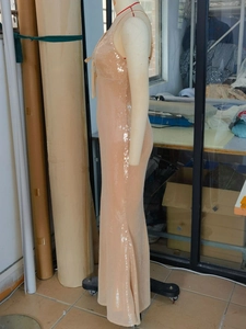 Detail of elegant apricot sequined maxi dress with slender straps and slim mermaid cut