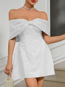 Detail of off-the-shoulder white dress with large bow and floral jacquard texture