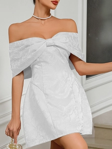Close-up of white off-the-shoulder party dress with floral jacquard and large bow detail