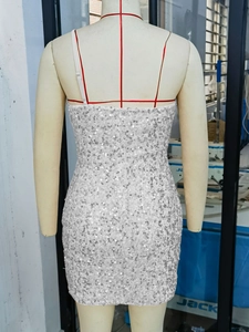 Detailed view of white sequin bodycon dress with thin straps and open back design