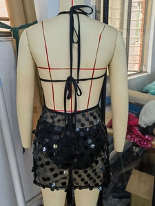Détail de la robe licou à paillettes noires montrant le dos nu et les liens en maille