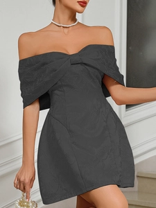 Detail of dark grey off-shoulder dress featuring floral jacquard fabric and bow