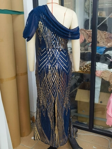 Detail view of navy sequin evening gown featuring geometric patterns and mesh cape