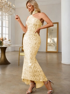Detail of shimmering gold sequins on a one-shoulder mermaid evening gown with luxury finish