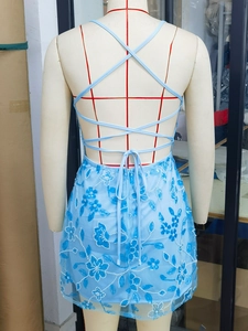 Détail du dos d'une robe courte bleu clair à paillettes avec lacets croisés et dos nu
