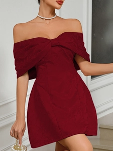 Close-up of elegant burgundy off-shoulder dress with large bow and floral jacquard texture