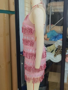Vue latérale de la robe rose à paillettes avec col licou et couches de franges