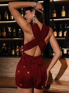 Detailed back view of burgundy sequin romper featuring a cross halter and large bow tie