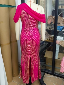 Detail of rose red one shoulder sequin dress featuring golden geometric texture and chiffon shawl