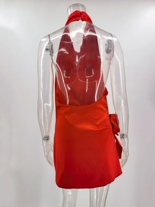 Detail of red satin backless mini dress with halter neck and bow tie feature