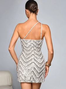 Détail d'une robe de soirée à paillettes argentées avec motif ondulé et dos nu