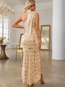 Detail of elegant gold sequin one-shoulder evening gown with flowing back ribbon tie