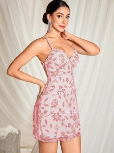 Détail de la broderie florale à paillettes rose clair sur une robe cocktail dos nu
