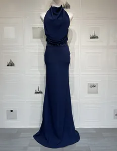 Détail de robe longue bleu marine à col licou avec taille à paillettes et ourlet queue de poisson