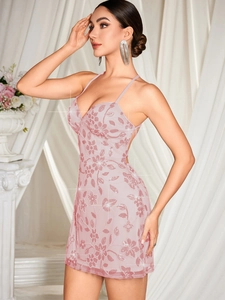 Détail d'une robe courte en dentelle rose pâle à paillettes avec broderies et décolleté en V