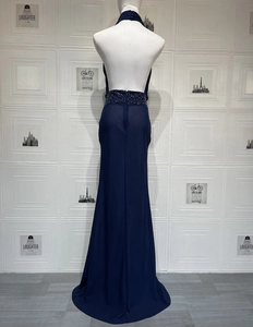 Détail de la robe de soirée dos nu bleu marine avec taille à paillettes et bouton au cou
