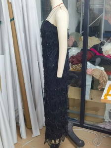 Detail of black sequined backless dress with fringe texture and floor-length silhouette