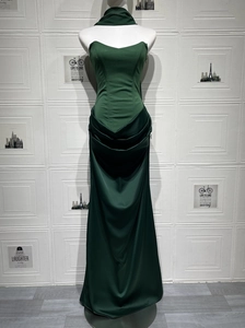 Detail of emerald green strapless satin dress featuring waist pleats and neck strap