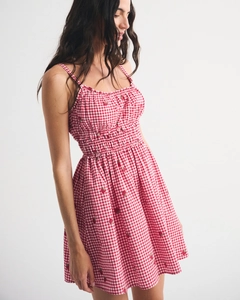 Detail of red gingham sundress with strawberry print and elastic smocking texture