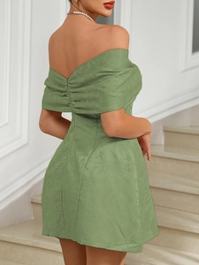 Close-up of grass green off-shoulder dress featuring backless floral jacquard texture