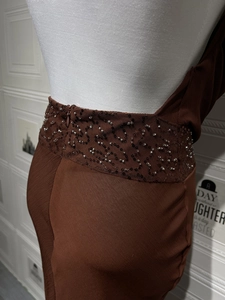 Détail de la broderie de paillettes et texture plissée sur une robe de soirée rouge