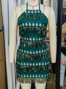 Détails des paillettes vert foncé et franges sur une robe de soirée dos nu courte