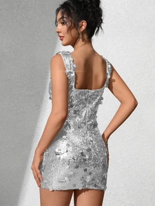 Détail d'une mini robe argentée à paillettes avec coupe ajustée et dos en forme de U