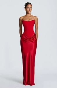 Detail of elegant red satin evening dress with corset bodice and draped wrap skirt