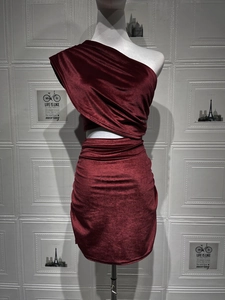 Texture détaillée du velours bordeaux sur une robe moulante sexy à une épaule