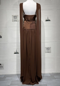 Dettaglio dell'abito in chiffon marrone con vita aderente e mantello lungo plissettato