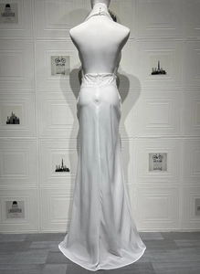 Détail de la robe blanche dos nu avec taille à paillettes et fermeture à bouton perle