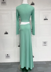 Détails d'un ensemble deux pièces vert menthe avec œillets métalliques et jupe longue ajourée
