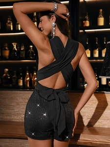 Detail of a black sequin romper with a large bow and an elegant open-back design