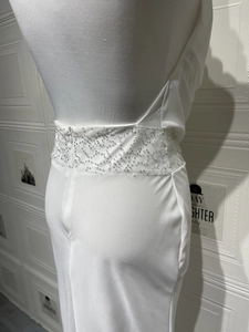 Détail du dos nu d'une robe blanche avec des paillettes argentées exquises à la taille