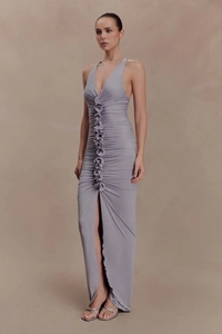 Detail of grey sleeveless maxi dress featuring central rosette ruffles and a high side slit