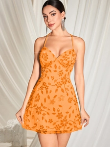 Détail de la broderie à paillettes orange sur une robe de soirée courte et sexy à col V