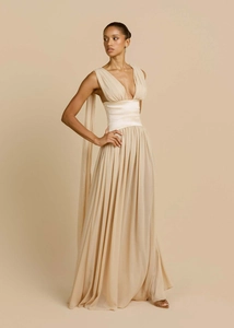 Dettaglio di un elegante abito da sera color champagne con scollo a V e gonna a pieghe
